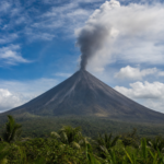 Mayon Vulkan auf den Philippinen mit perfektem Kegel und Aschewolke ueber tropischer Landschaft